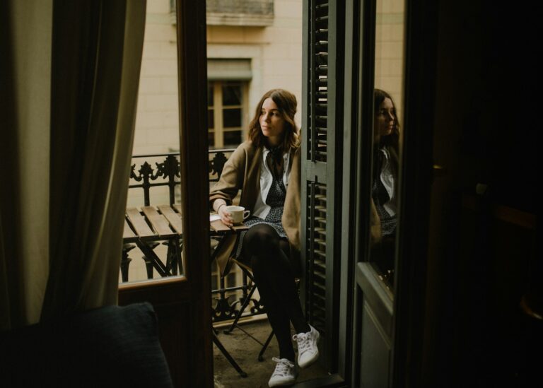 woman sitting on chair holding cup on a Barcelona balcony