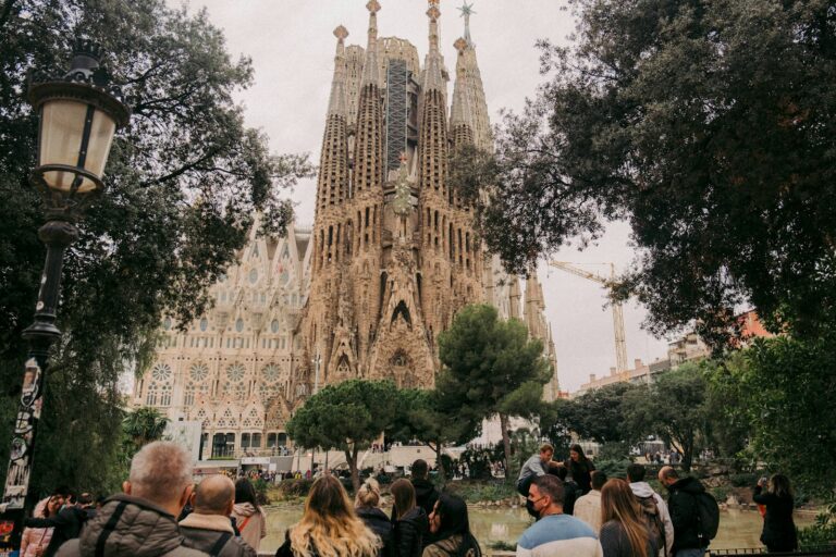 a crowd of people walking in front of a Sagrada Familia